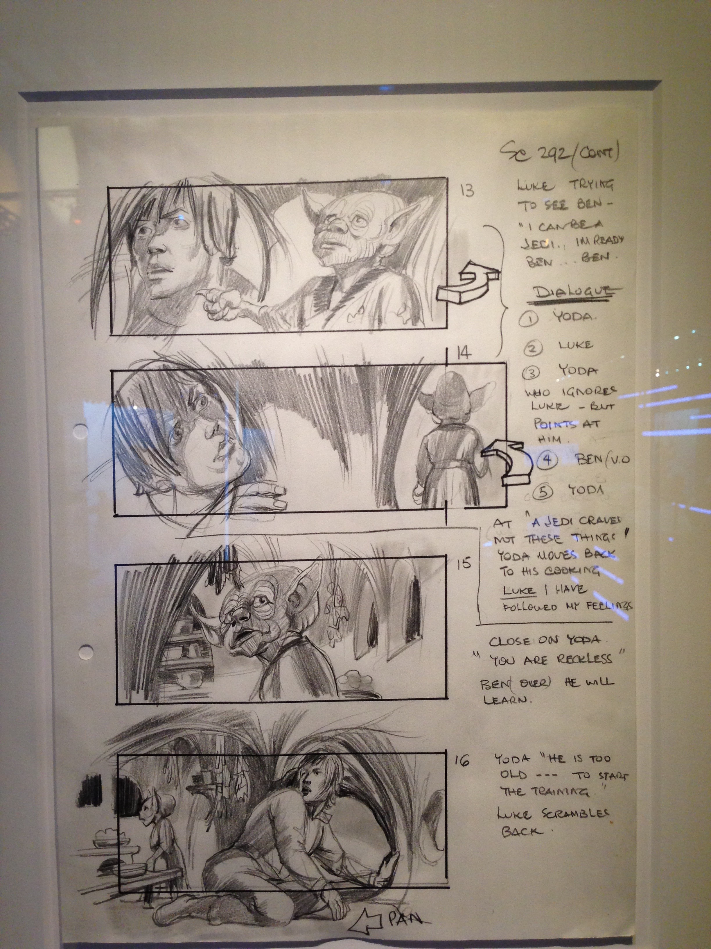 A pencil storyboard sheet — quick gestural sketches of the Dagobah hut scene, framed as panels 13–16, with handwritten dialogue and camera notes down the right-hand side (Luke trying to see Ben; Yoda; Ben’s voiceover) and a small hand-drawn 3-D arrow beside frames 13–14 marking a camera pan.